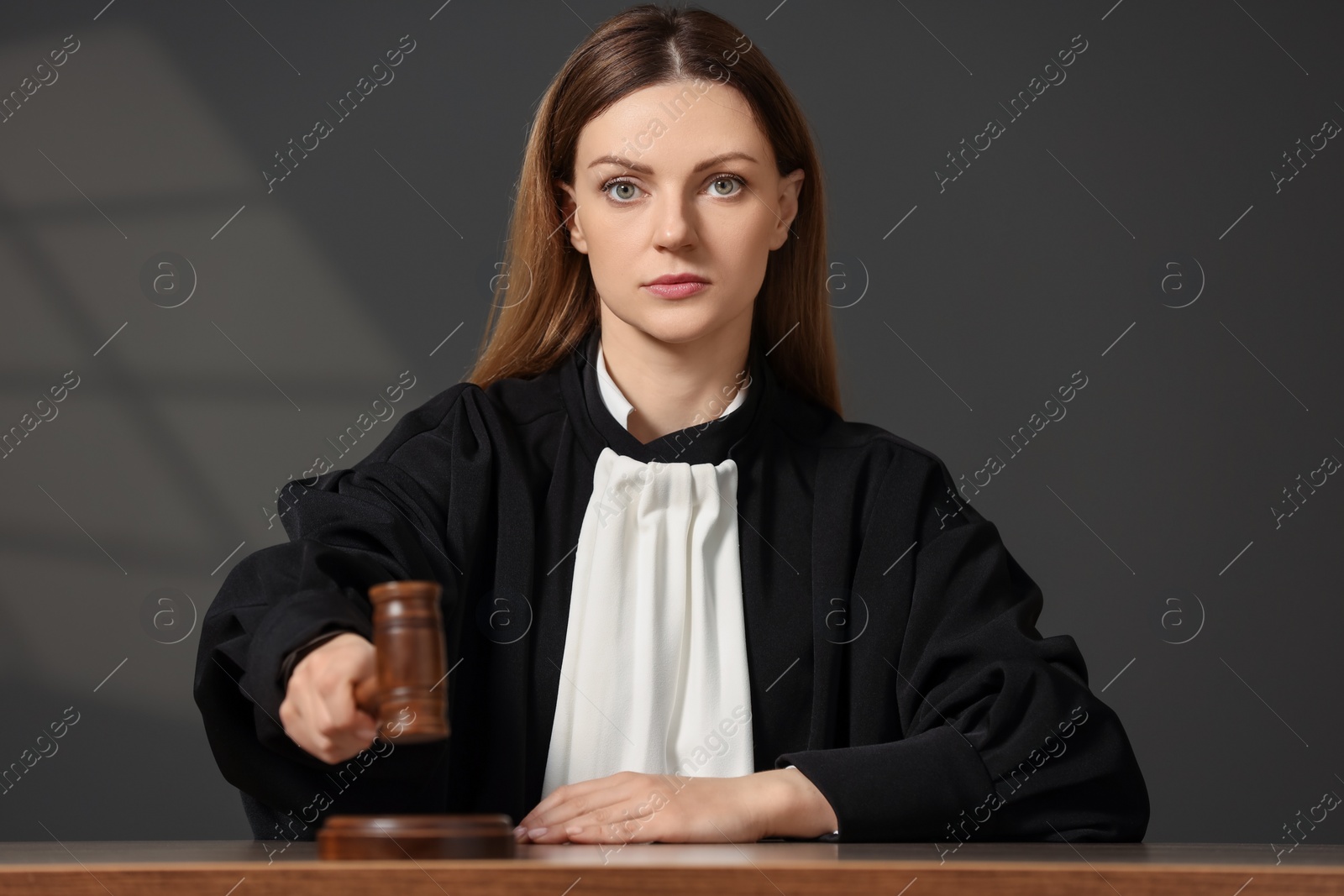 Photo of Judge striking mallet at wooden table in courtroom