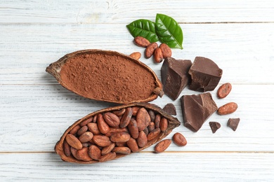 Photo of Flat lay composition with cocoa pods and chocolate on white wooden table