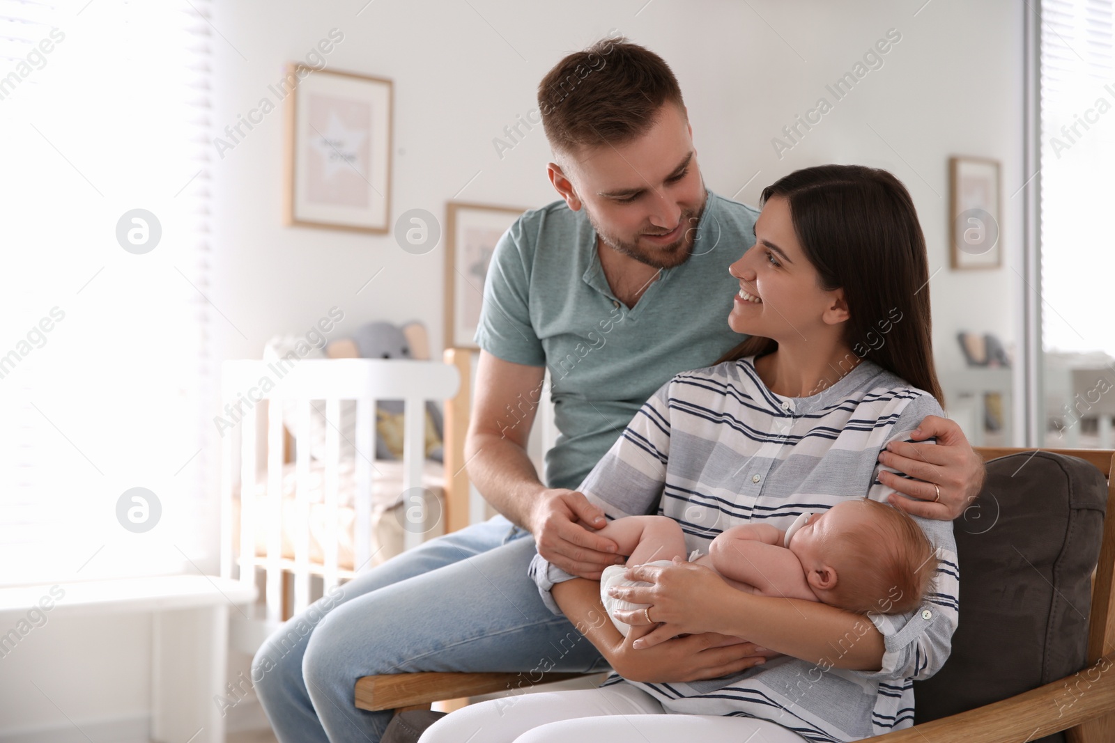 Photo of Happy couple with their newborn baby at home