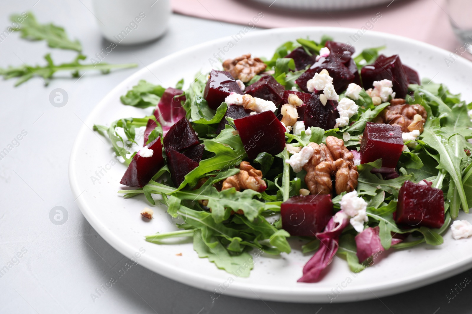 Photo of Delicious beet salad served on grey table, closeup