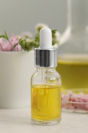 Photo of Bottle of cosmetic oil on white table, closeup