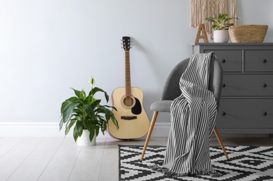 Chair with soft plaid in stylish room interior