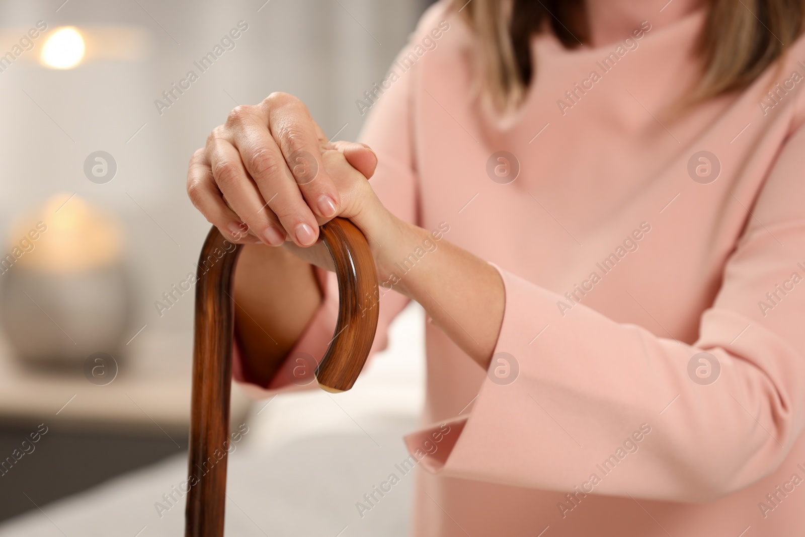 Photo of Mature woman with walking cane indoors, closeup