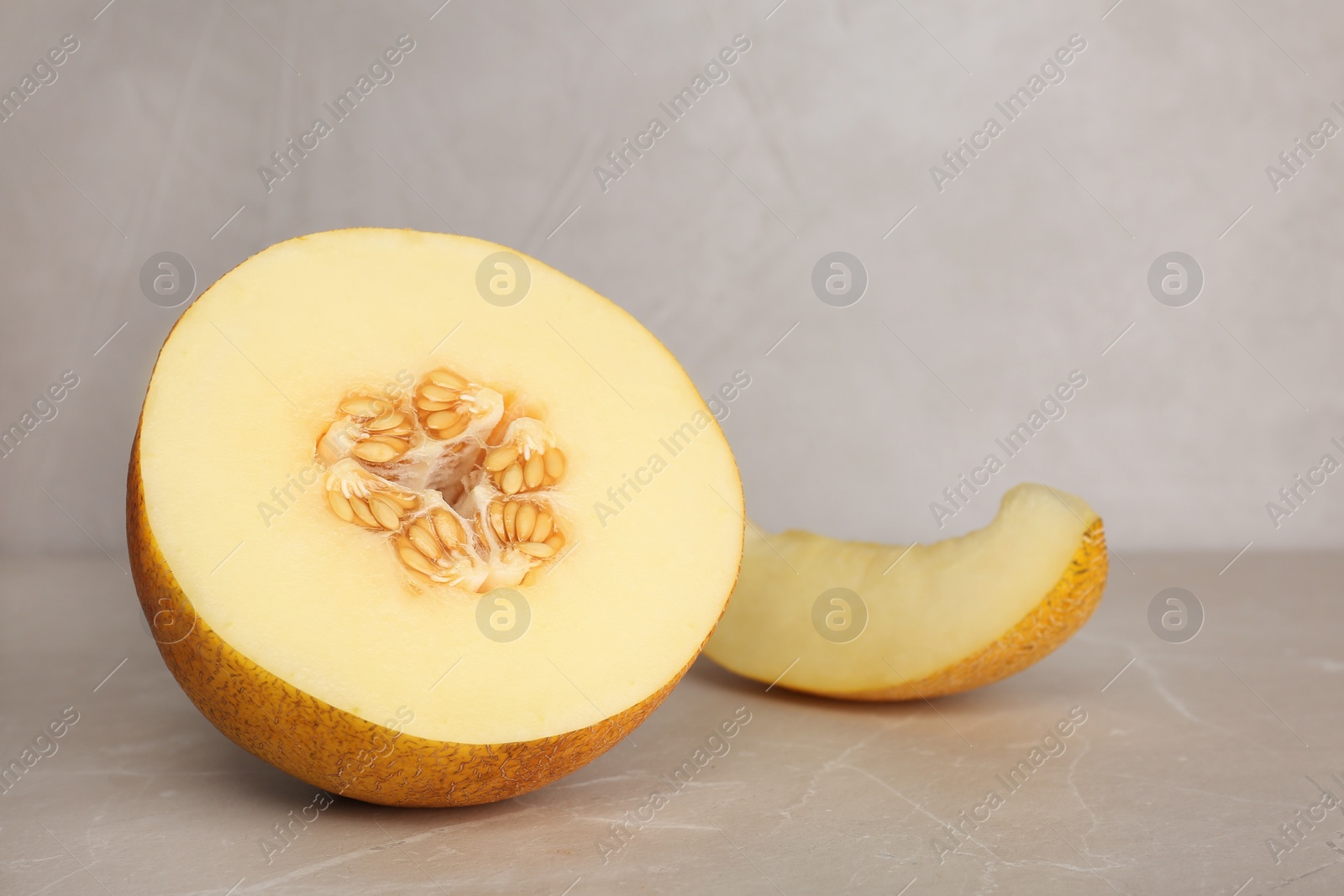 Photo of Cut sweet melon on table against gray background. Space for text