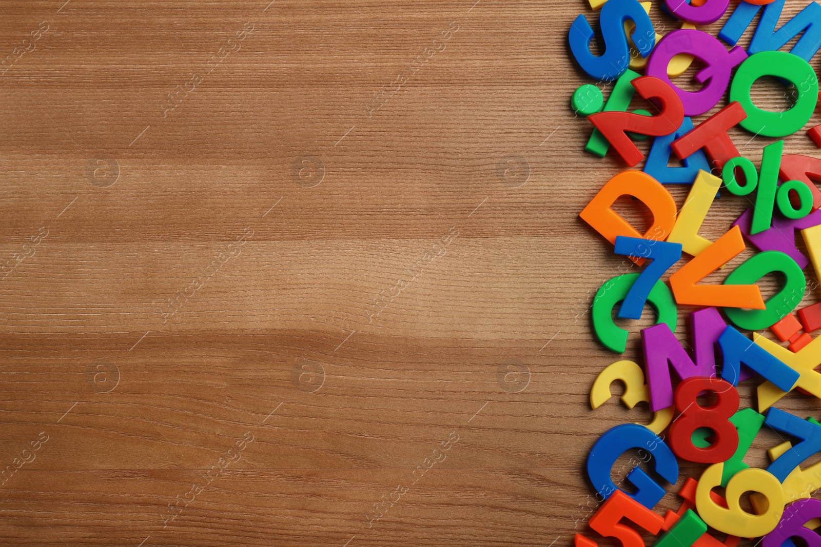 Photo of Plastic magnetic letters on wooden background, top view with space for text