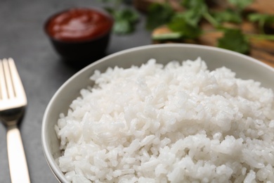 Photo of Bowl of boiled rice on table, closeup