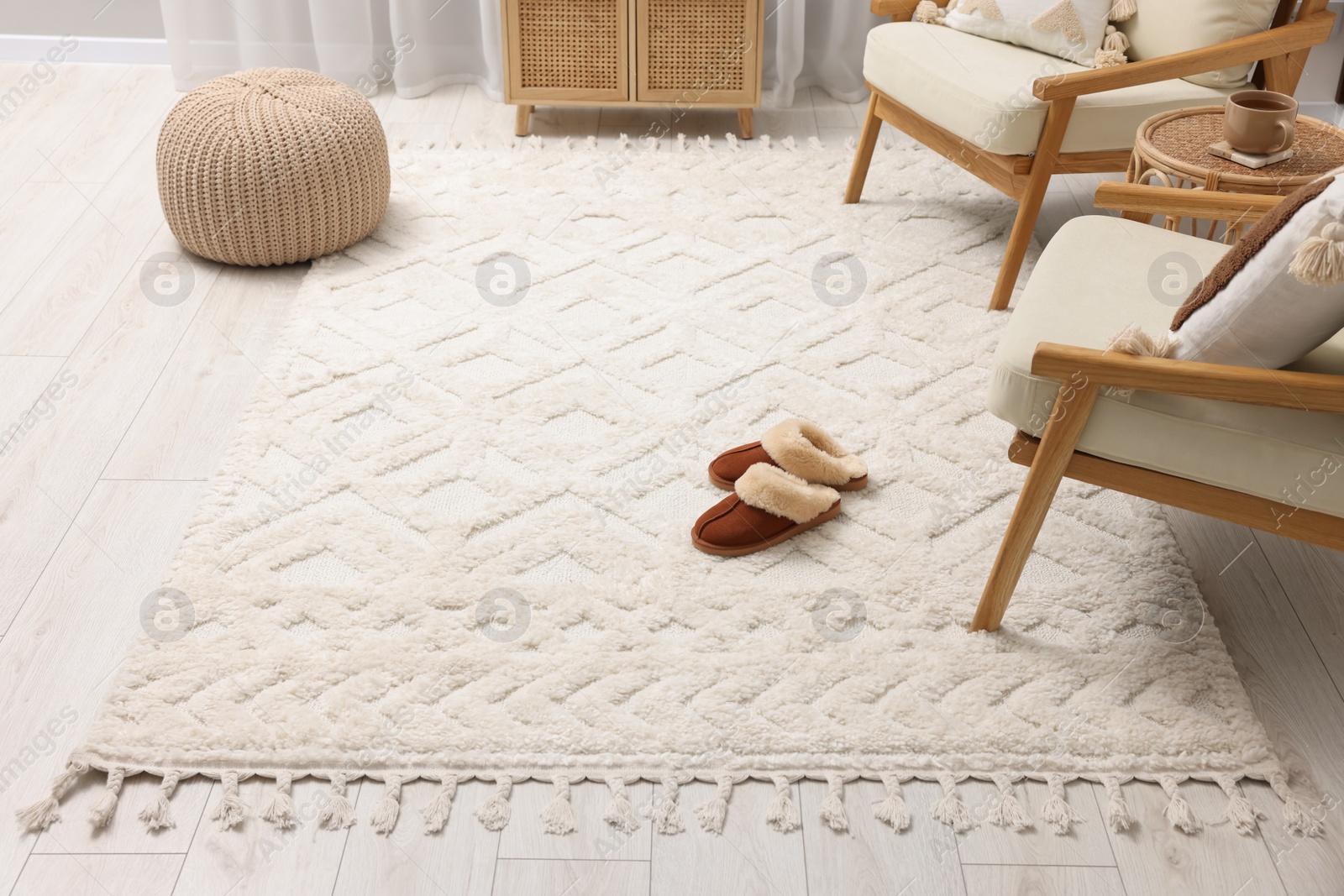 Photo of Slippers on soft white carpet in living room