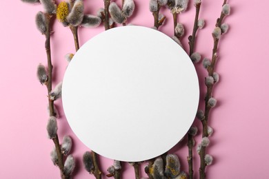 Photo of Beautiful blooming willow branches and blank paper card on pink background, flat lay. Space for text