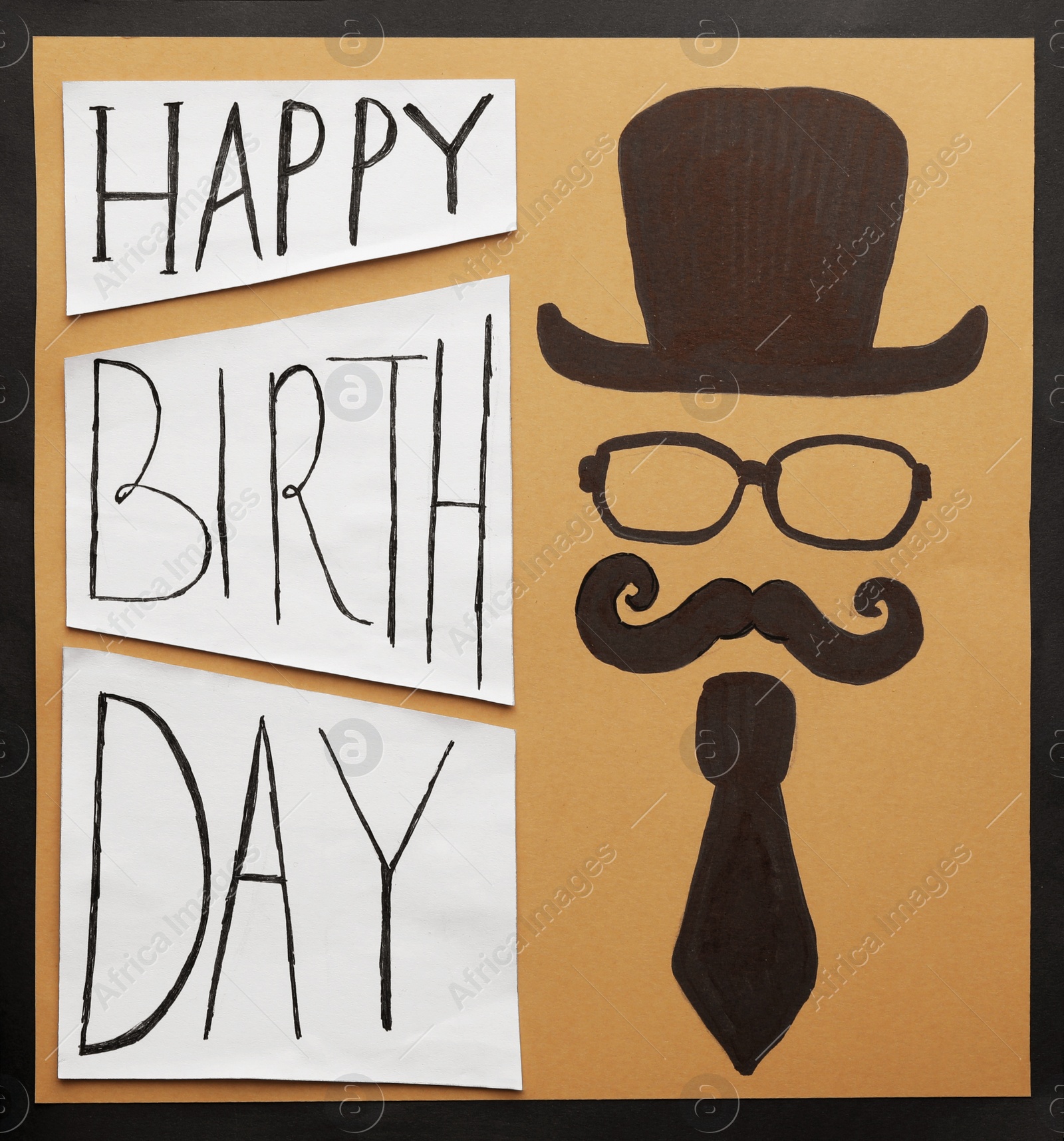 Photo of Cardboard card with words HAPPY BIRTHDAY and funny picture on black background, top view