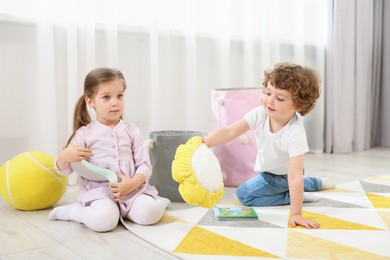 Photo of Cute little children playing together on floor in kindergarten