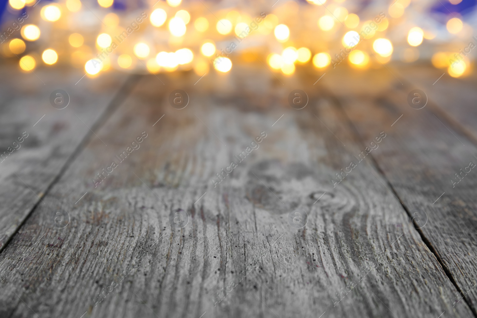 Photo of Wooden table and blurred Christmas lights on background