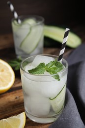 Photo of Refreshing cucumber water with mint on wooden table, closeup
