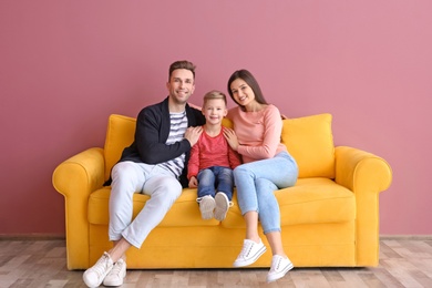 Photo of Happy family sitting on sofa, indoors