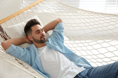 Young man relaxing in hammock at home