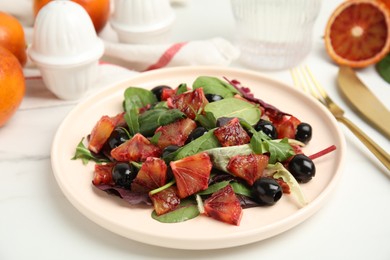 Photo of Delicious salad with sicilian orange on white table, closeup