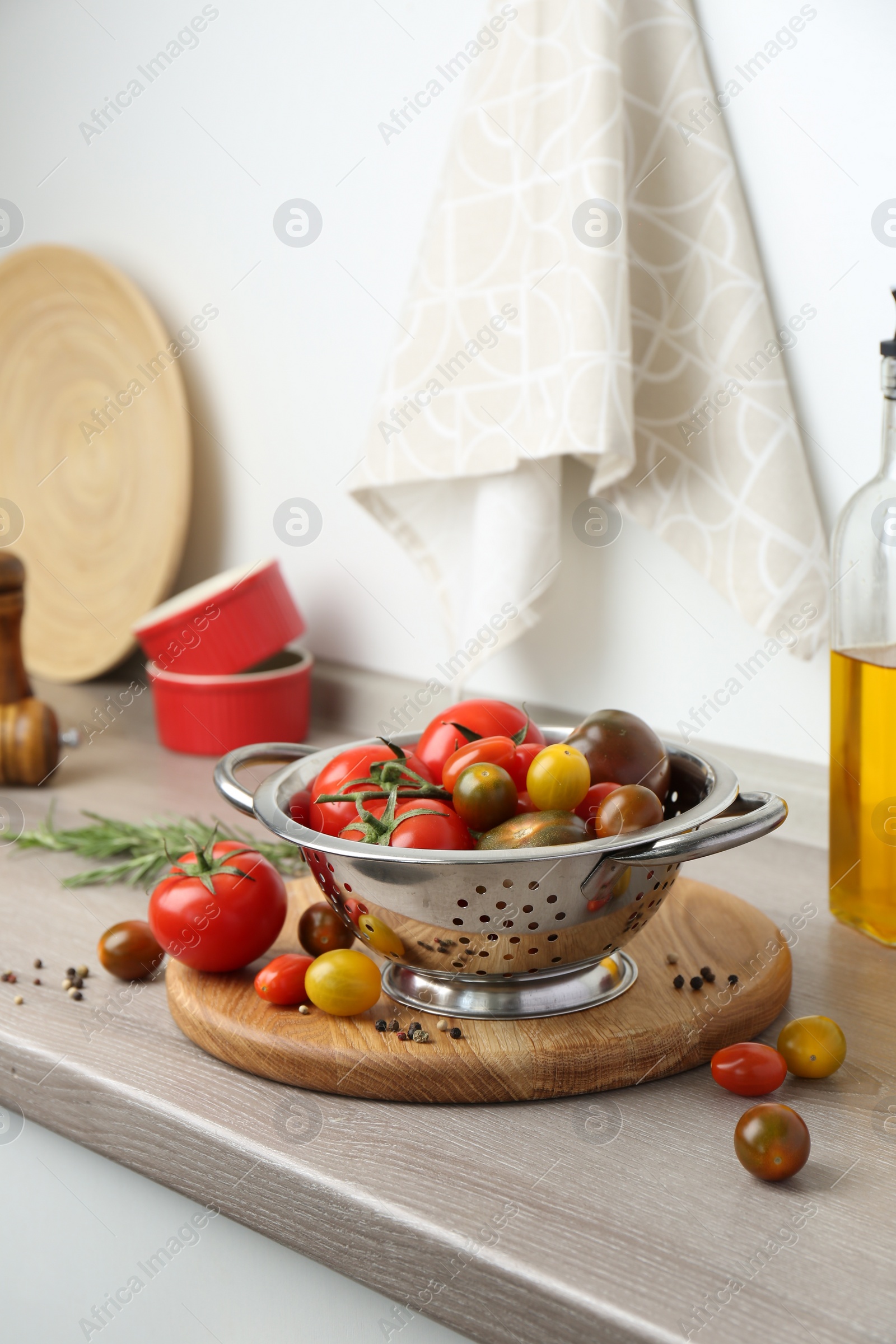 Photo of Metal colander with tomatoes on countertop in kitchen