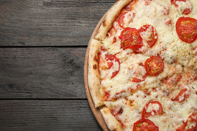 Photo of Delicious pizza Margherita on wooden table, top view. Space for text