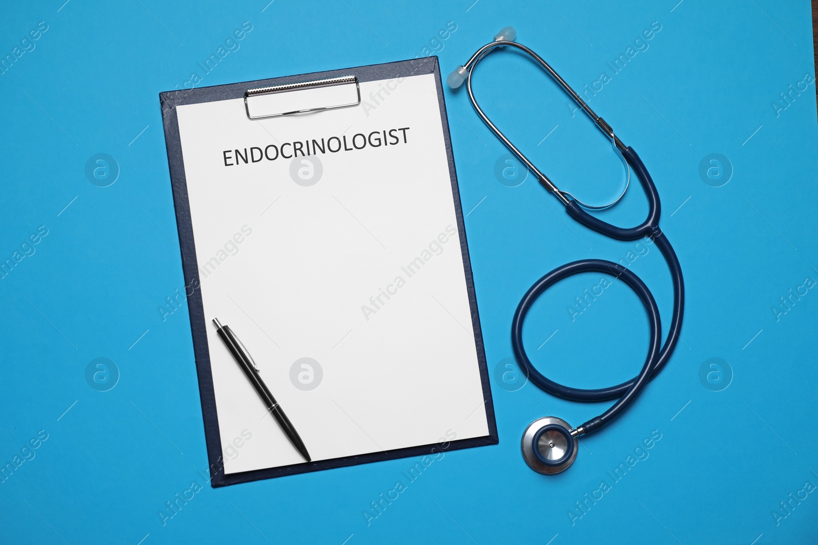 Image of Endocrinologist. Clipboard, stethoscope and pen on light blue background, top view