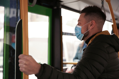 Photo of Man with disposable mask on bus. Virus protection