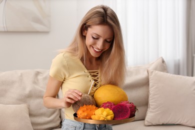 Young woman with fresh exotic fruits at home
