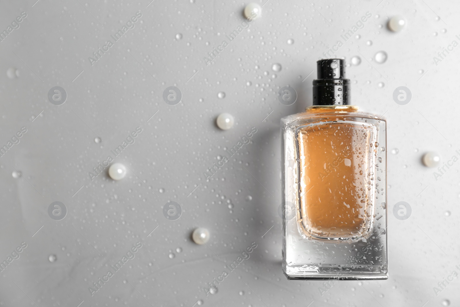 Photo of Perfume bottle on light background, flat lay