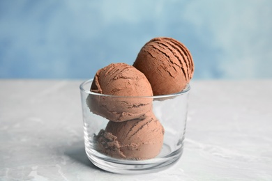 Photo of Glass of chocolate ice cream on grey table
