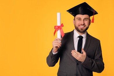 Happy student with graduation hat and diploma on yellow background. Space for text