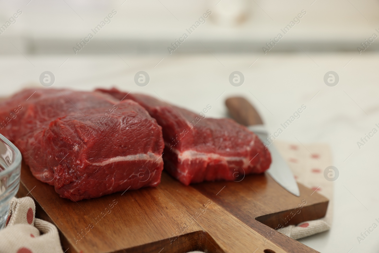 Photo of Board with beef meat on white table, closeup