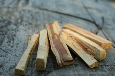 Photo of Palo santo sticks on wooden table, closeup