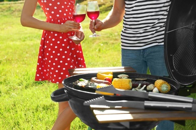 Photo of Couple having barbecue in park, closeup view