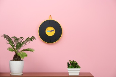 Photo of Stylish clock hanging on wall in room. Time of day