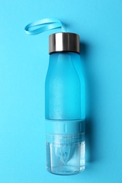 Photo of Sport bottle with water on color background