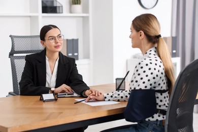 Injured woman having meeting with lawyer in office