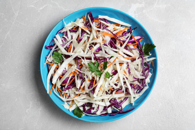 Tasty salad with cabbage on light grey marble table, top view