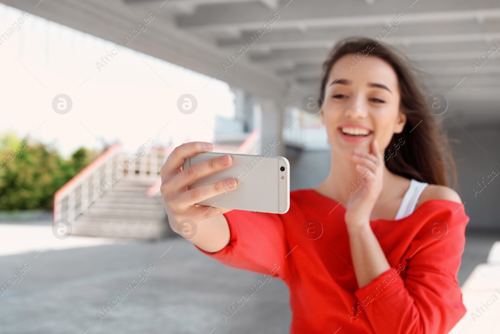 Photo of Attractive young woman taking selfie with phone outdoors