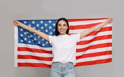 Photo of 4th of July - Independence Day of USA. Happy woman with American flag on light grey background