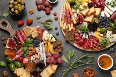 Photo of Different tasty appetizers on dark grey table, flat lay