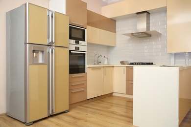 Interior of spacious modern kitchen with refrigerator