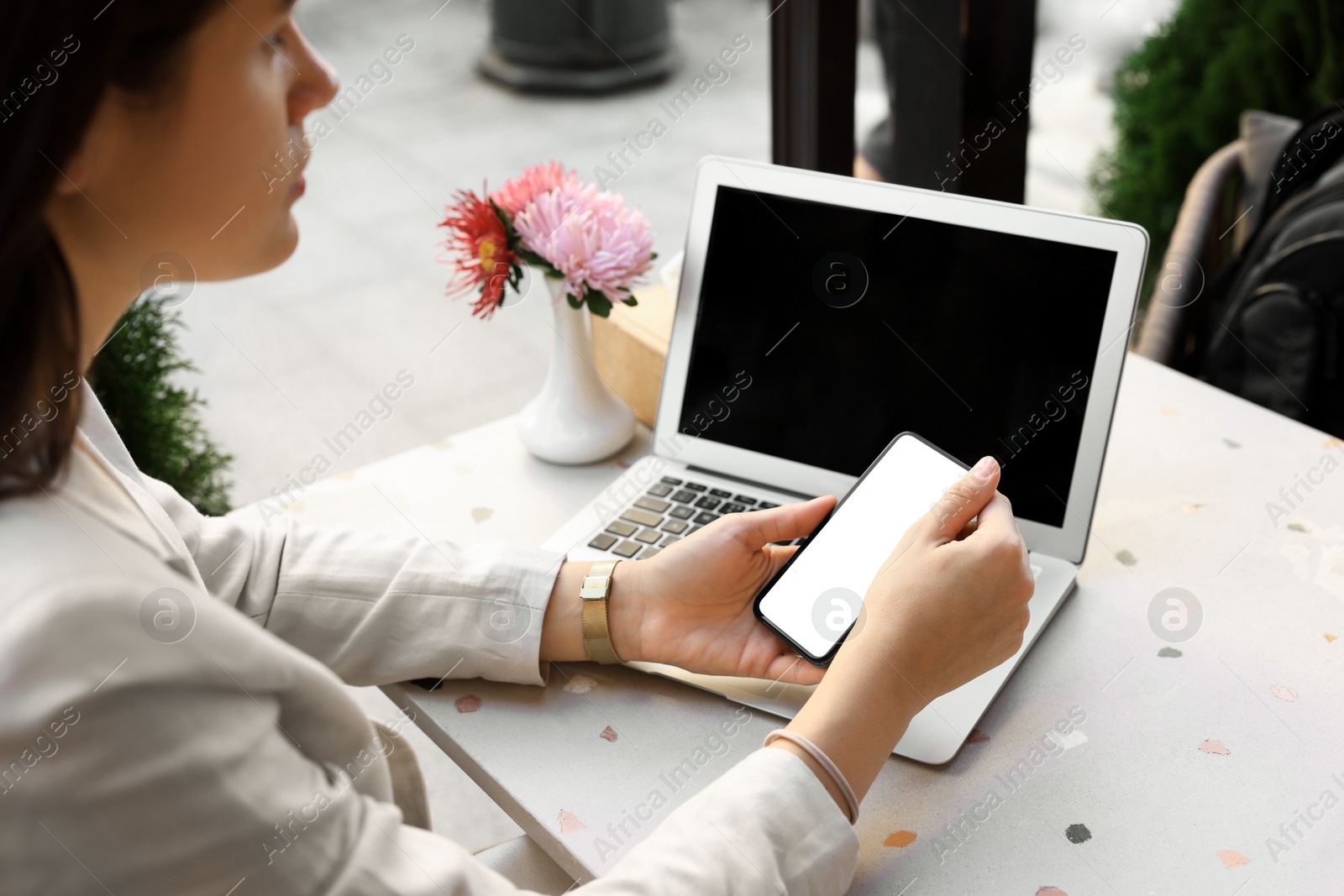 Photo of Woman using smartphone at table in outdoor cafe, closeup