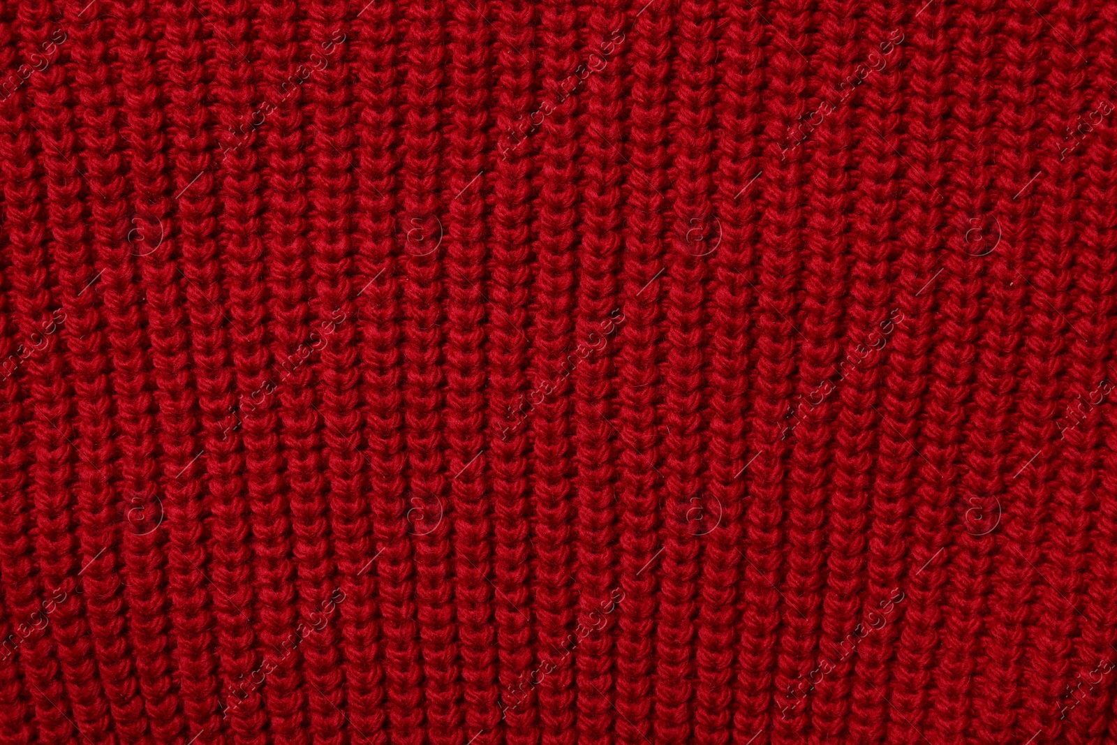 Photo of Texture of soft red knitted fabric as background, top view