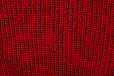 Texture of soft red knitted fabric as background, top view