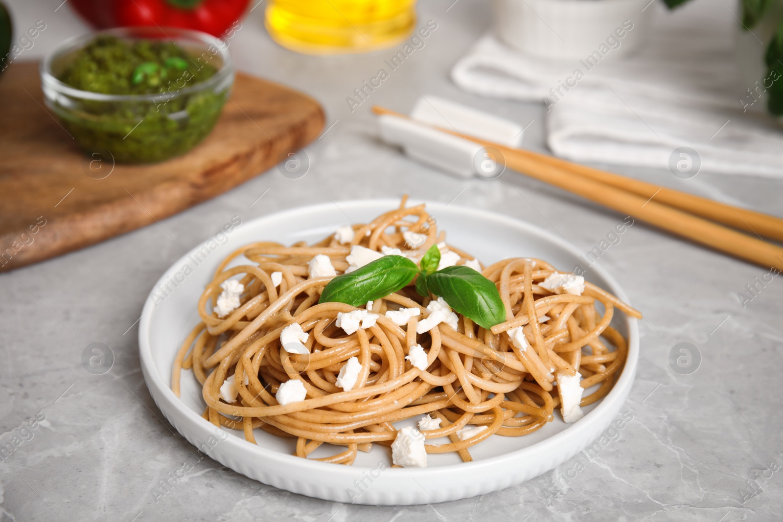 Photo of Tasty buckwheat noodles served on light grey table