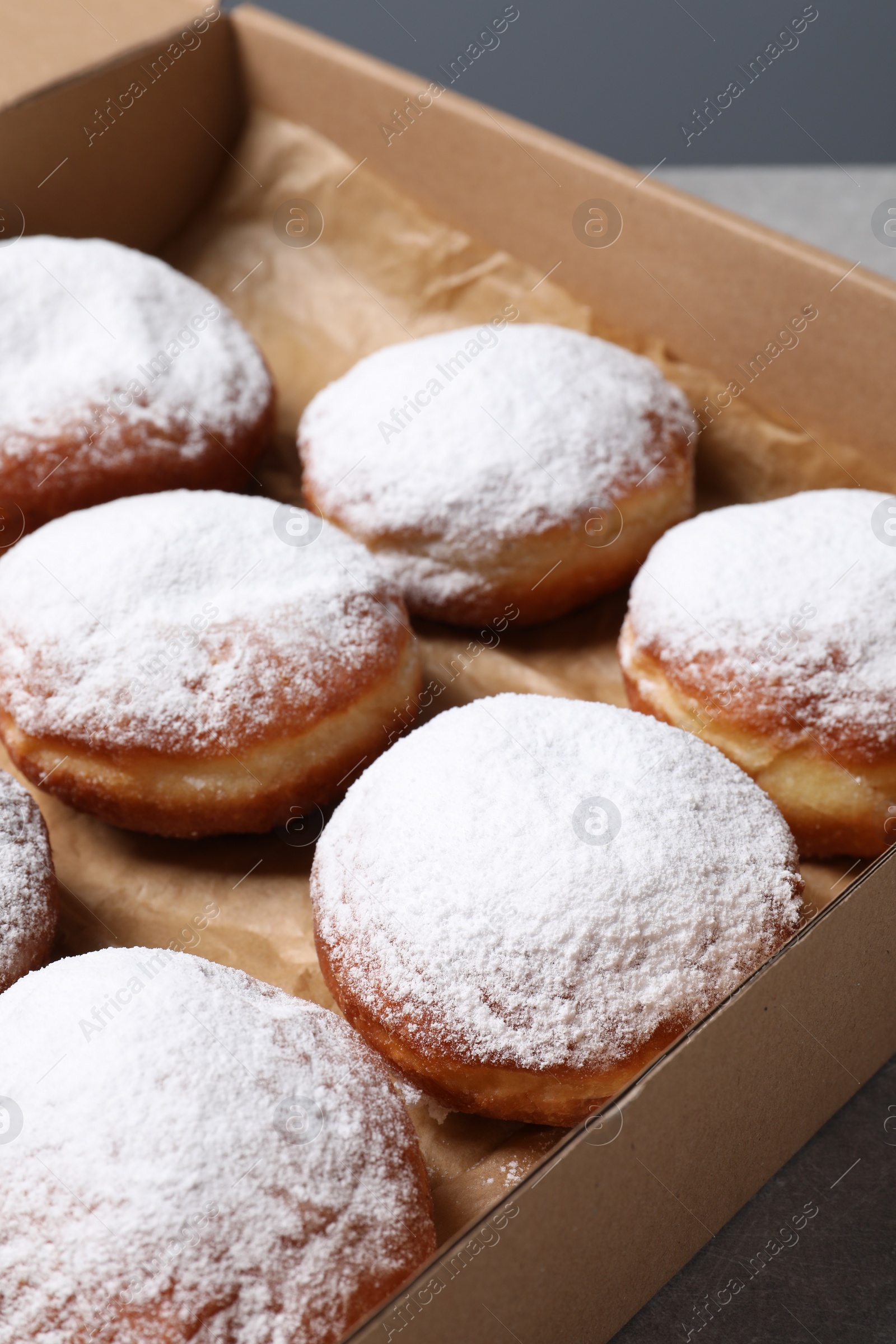 Photo of Delicious buns with powdered sugar on table, closeup