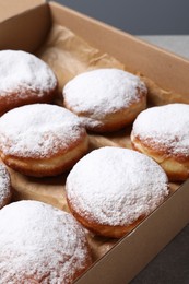 Photo of Delicious buns with powdered sugar on table, closeup