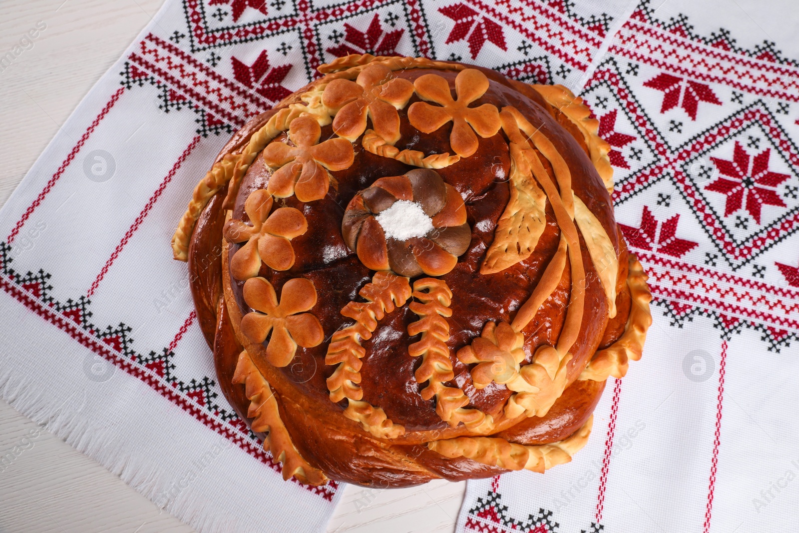 Photo of Korovai on rushnyk, top view. Ukrainian bread and salt welcoming tradition