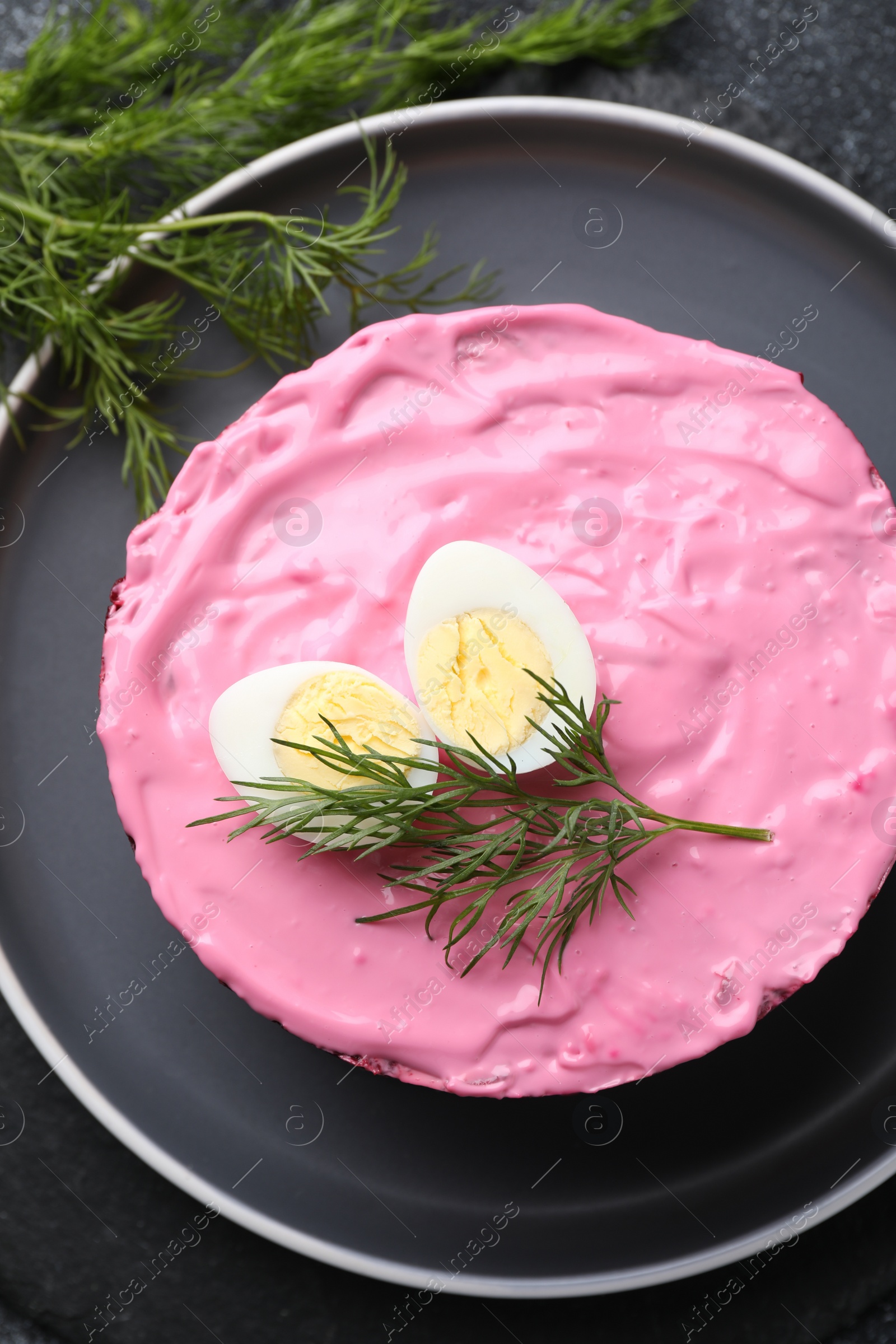 Photo of Herring under fur coat salad on grey table, top view. Traditional Russian dish