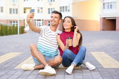 Young couple taking selfie on city street