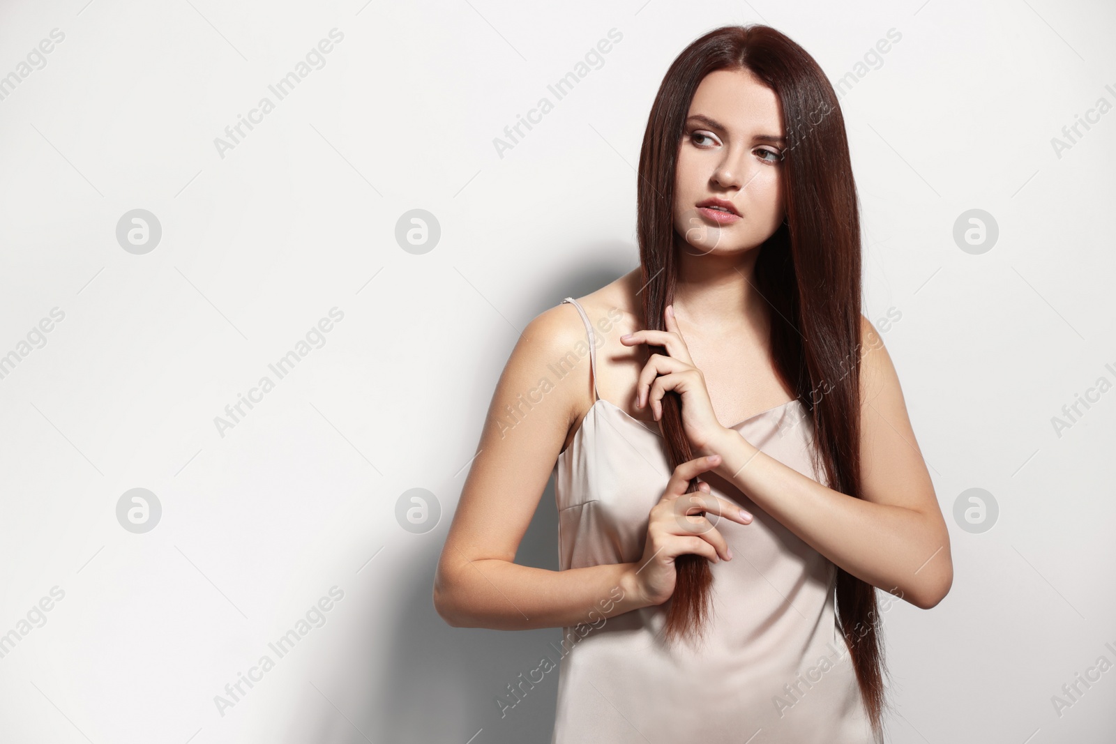 Photo of Portrait of beautiful young woman with healthy strong hair on light gray background, space for text