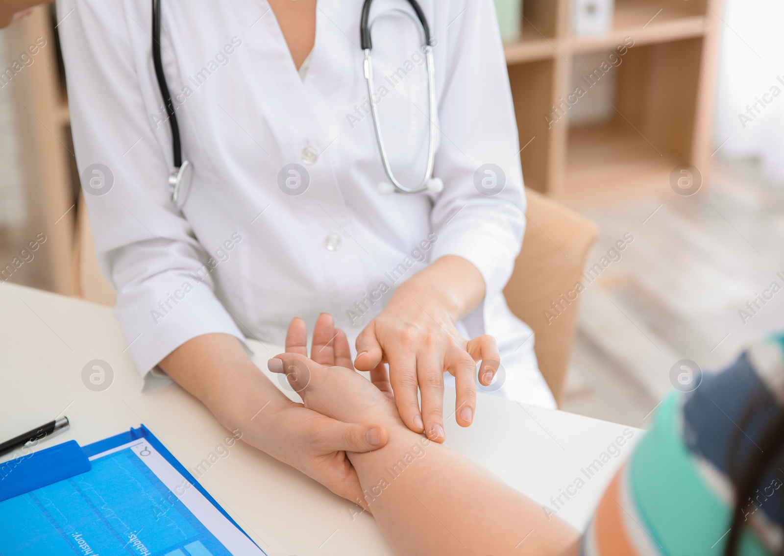 Photo of Young female doctor taking pulse of overweight woman in clinic