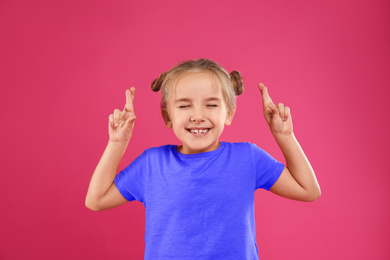 Photo of Cute little girl posing on pink background